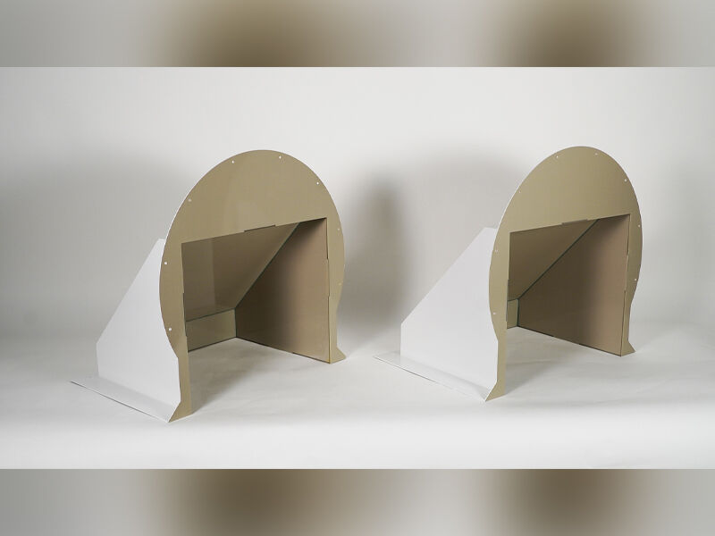 Image shows two cable cover structures for the multiband large ground-based radome. The structures have tan interiors and white exteriors. They are placed on a table and a white background.